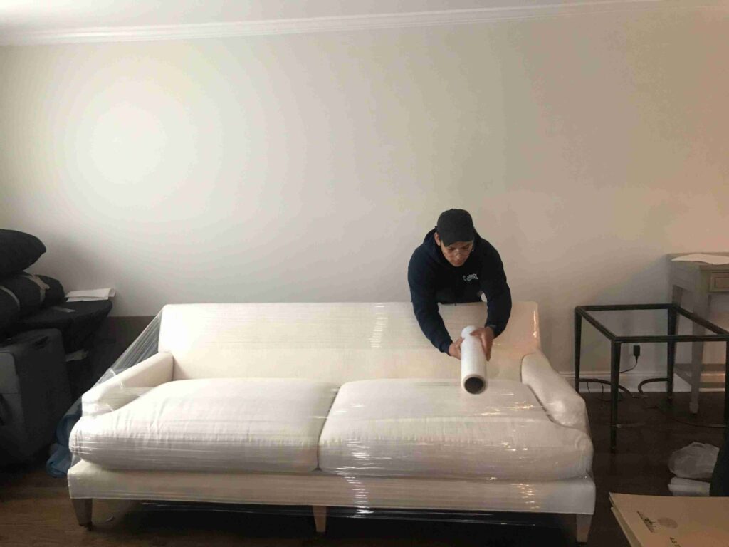 a person wrapping a sofa