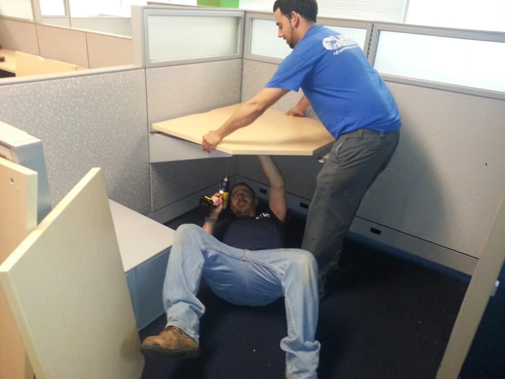 2 crew from Clancy Relocation & Logistics are disassembling furniture.